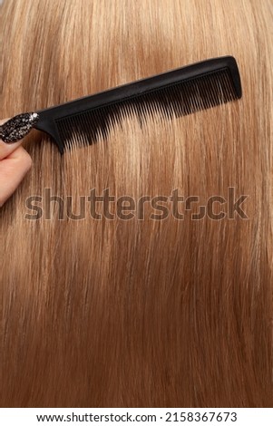 Beautiful straight smooth long hair and black comb, hair care concept