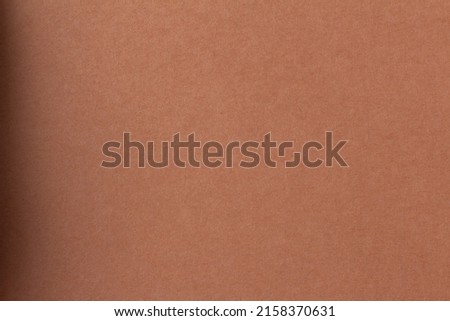 The texture surface of the brown paper sheet with a shadow on the left side and a gradient. Elegant background for graphics and design. Blank for posters and banners