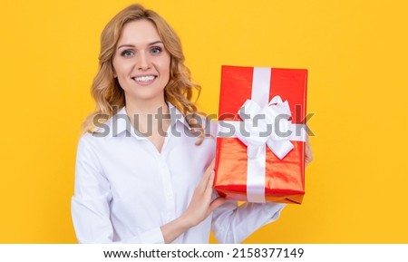 smiling woman hold big present box on yellow background