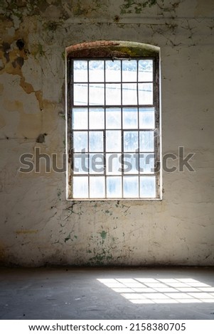 Abandoned Industrial Factory Warehouse Interior. Huge window to the floor all over the concrete wall with a wooden sill. Grunge industrial loft interior. Brick and light background. a large window. 
