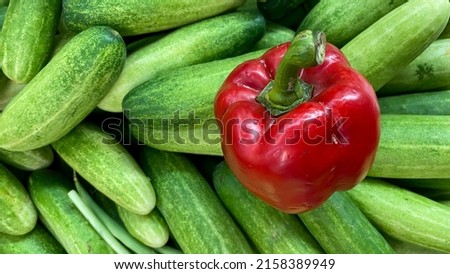 red paprika or pepper on a pile of cucumbers