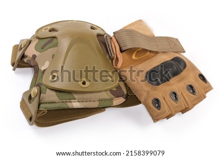 Used tactical military knee pad and combat leathern fingerless glove on a white background Royalty-Free Stock Photo #2158399079