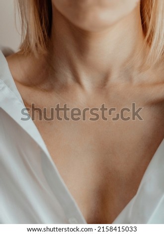 Close-up of a young woman's neck and collarbone. Lines on the neck. Wrinkles, age-related changes, rings of Venus, goosebumps. Royalty-Free Stock Photo #2158415033