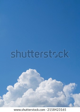 Summer sky background, white cloud on clear blue sky, vertical photo.
