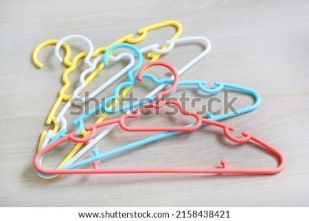 Colored plastic Clothes Hangers on wooden background