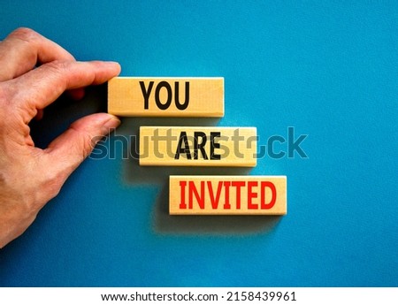 You are invited symbol. Concept words You are invited on wooden blocks. Businessman hand. Beautiful blue table blue background. Business and you are invited concept. Copy space.