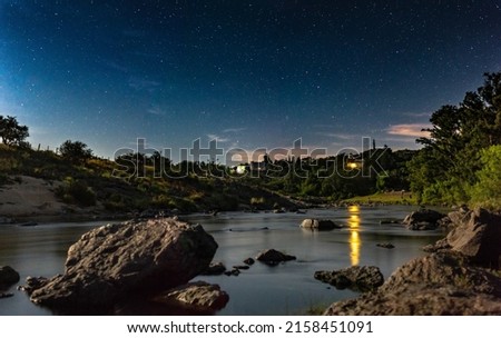 A beautiful view of a lake with a starry night sky background