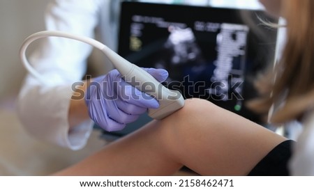 Doctor conducting ultrasound examination of knee joint in child closeup. Diagnosis of bone diseases in children concept Royalty-Free Stock Photo #2158462471