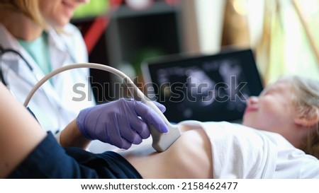 Doctor conducting ultrasound examination of internal organs of child in clinic. Diagnosis and treatment of diseases of liver and biliary tract in children concept Royalty-Free Stock Photo #2158462477