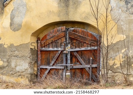 Broken wooden gate of an old ruined building. Old ruined gates with brown antique timber gate 