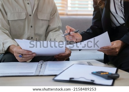 Cropped shot of insurance broker or financial advisor offering health insurance for elderly clients in office. Royalty-Free Stock Photo #2158489253