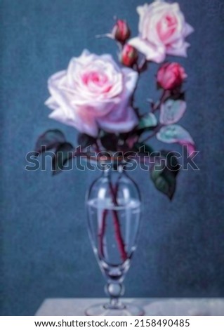 The background blured trxrure is a beautiful flower picture displayed on the table.
