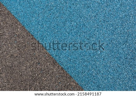 Blue and black rubber coating for playgrounds applied on the surface by a steel trowel. PDM rubber granules. Coating and floor covering for sports. Rubber mulch for safety and injury prevention Royalty-Free Stock Photo #2158491187