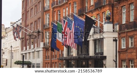 A vi0ew of several flags of Ireland, Great Britain, the European Union and the US on the entrance of a building in London
