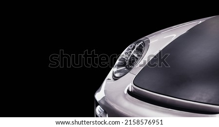 Front right side view of a beautiful shiny gray sports car in a black background with a negative space. Perfect for advertisements and commercial use.