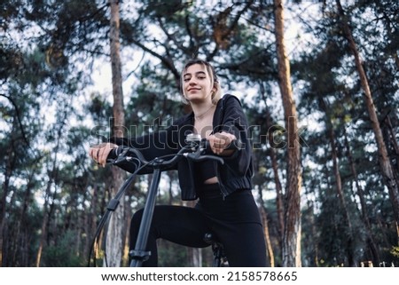 young and beautiful woman riding folding bike in the park