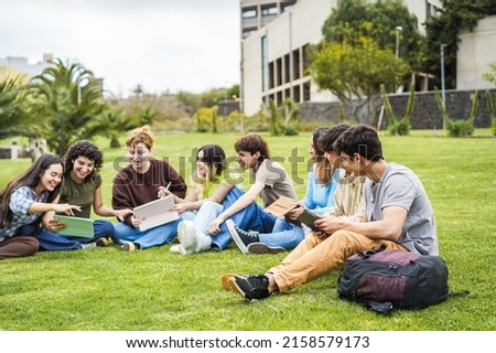 Young friends studying together outdoor sitting in university park - Focus on right guy face Royalty-Free Stock Photo #2158579173