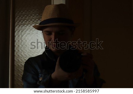 Defocus young woman take photography in mirror reflection. Millennial woman in hat. Dark black portrait. Mental health. Narcissism. Photographer. Out of focus.