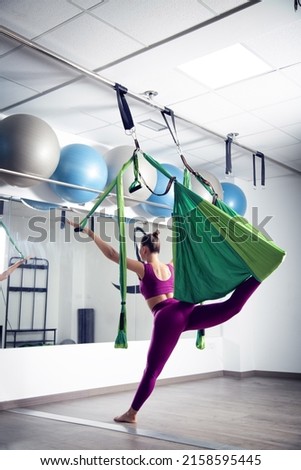 A vertical shot of a Caucasian woman exercising in the gym