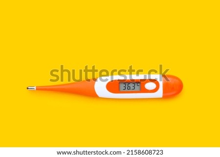 Thermometer on yellow background. Top view