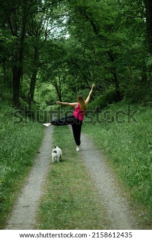 blonde walks through the woods, wears a turquoise t-shirt  the girl is dancing