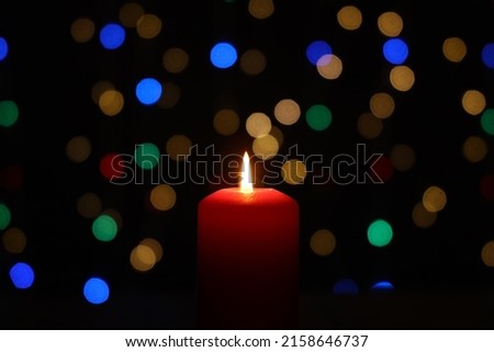 A closeup photo of a burning candle with a beautiful bokeh in the background