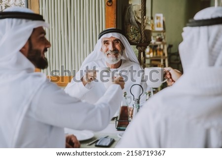 Three business men having a tea in Dubai wearing traditional emirati clothes Royalty-Free Stock Photo #2158719367