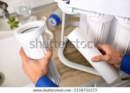 Technical changing filters for the maintenance of domestic reverse osmosis with filters in the background next to the sink. Elevated view. Horizontal composition. Royalty-Free Stock Photo #2158731273