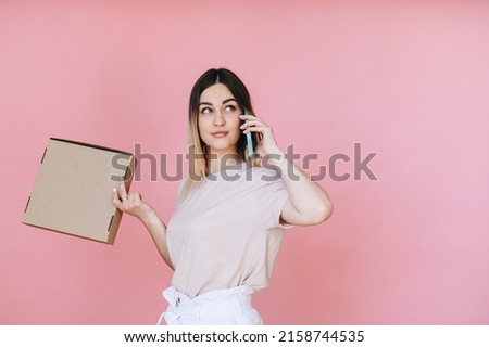 The girl ordered pizza at home on a pink background. Girl in casual clothes. Place for advertising