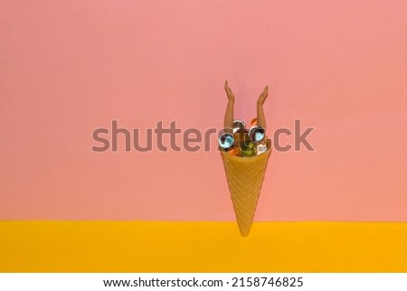 cone ice cream with abstract colorful molecular balls and hands coming out of them, creative summer design on a yellow-PINK background