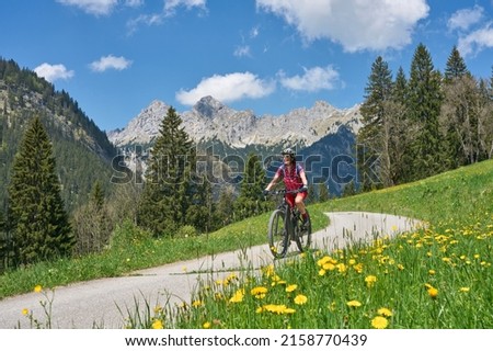 nice senior woman riding her electric mountain bike on the old Gaicht Pass road from Lech Valley up to the Tannheim Valley in Tyrol, Austria Royalty-Free Stock Photo #2158770439