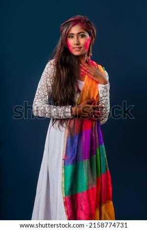 A beautiful young girl plays with colors on the occasion of Holi. The concept for the Indian festival Holi