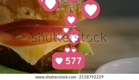Image of hearts and social media reactions over burger with cheese. american cuisine and fast food concept digitally generated image.