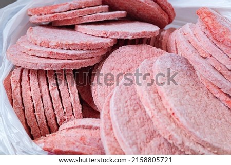 Frozen hamburger beef patties. Semi-finished products for fast-food.
