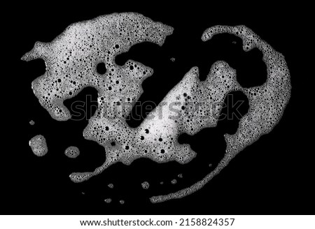 Top view, liquid white foam from soap or shampoo or shower gel. Abstract bubbles. isolated on a black background