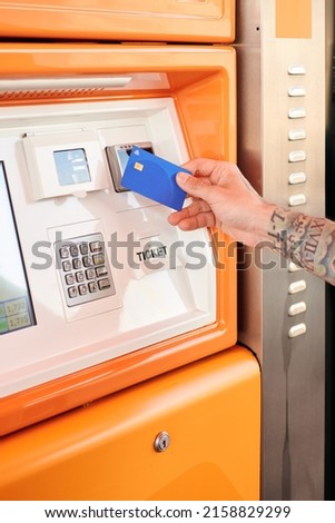Close-up of a man paying with a credit card at a gas station