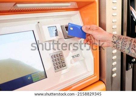 Close-up of a man paying with a credit card at a gas station