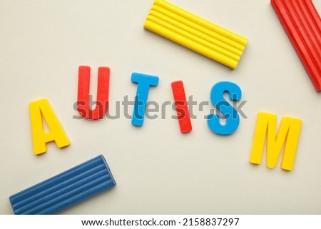 Autism. Autism spectrum disorder. Autism word made with playdough on grey background. Top view