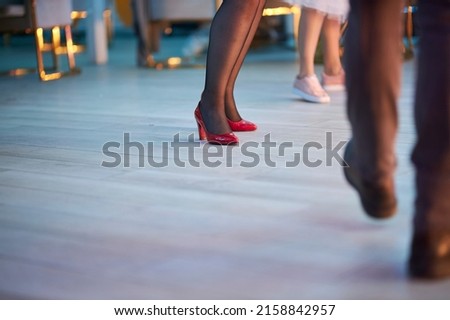 Dancing people on the dance floor. People are dancing, legs close up. Silhouettes of dancing people on the dance floor.  