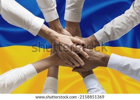 Hands o people united on ukrainian flag hands together over the national flag of Ukraine, in demonstration of union against the war escalation. Resistance of the Ukrainian people to the war against th