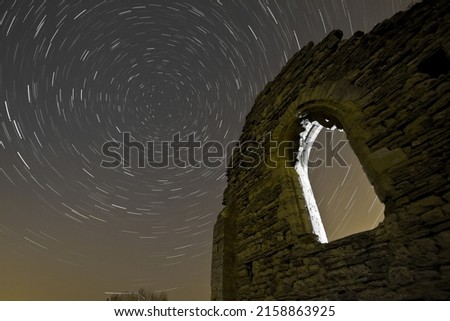 A beautiful view of a star trail over the abandoned ruined church