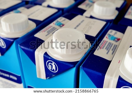 Easy to open screw caps on rows of milk cartoon boxes or packaging to allow consumers to re-close and keep the content fresher. Closeup view. Royalty-Free Stock Photo #2158866765