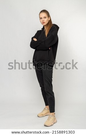 Girl in black cargo pants and black hoodie isolated on white