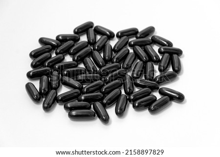 Black vitamins, pills in the shape of a ellipse on a white background. For pharmacies, backgrounds, medicine, vitamins, healthcare workers Royalty-Free Stock Photo #2158897829