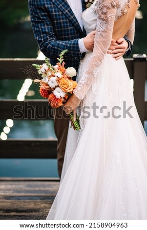 Close-up of groom's hand holding bride's wirst tender. Wedding picture 