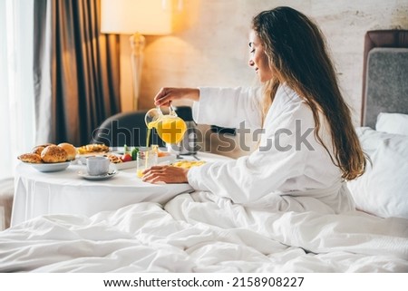 Woman eating breakfast in the hotel room. Room service breakfast in hotel room.  Royalty-Free Stock Photo #2158908227