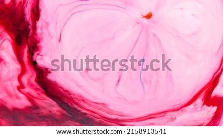 Pink liquid abstract surface. Colorful spots on a water surface. Fluid art texture with pink stains on the liquid