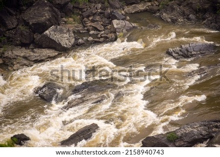 High speed water gushing out and making rapids when collided with rocks Royalty-Free Stock Photo #2158940743