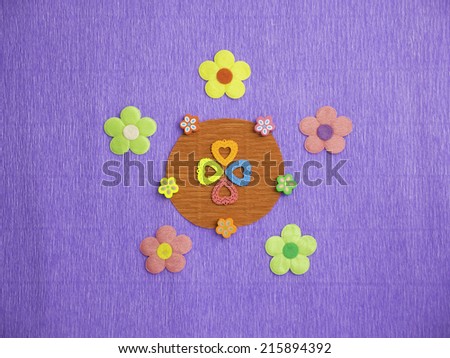 Symmetrical patterns of colorful flowers on a blue crepe-paper background with 4 hearts of different colors at its center