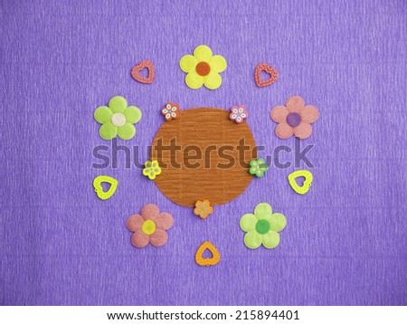 Symmetrical patterns of colorful flowers and hearts on a blue crepe-paper background with a blank space at its center